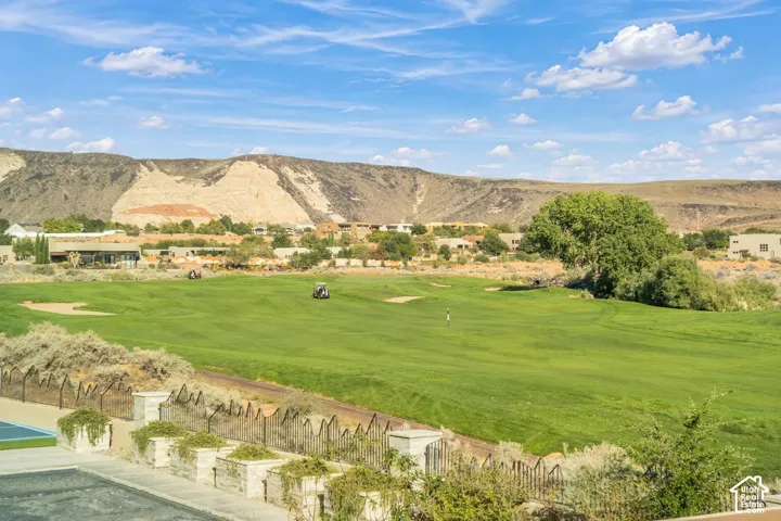 Expansive golf course grounds featuring manicured turf, sand bunkers, and a backdrop of arid mountain terrain
