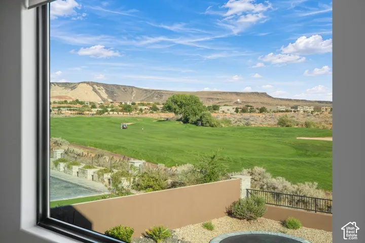 Expansive window with natural light, solid wall perimeter, desert landscaping, and mountain scenery