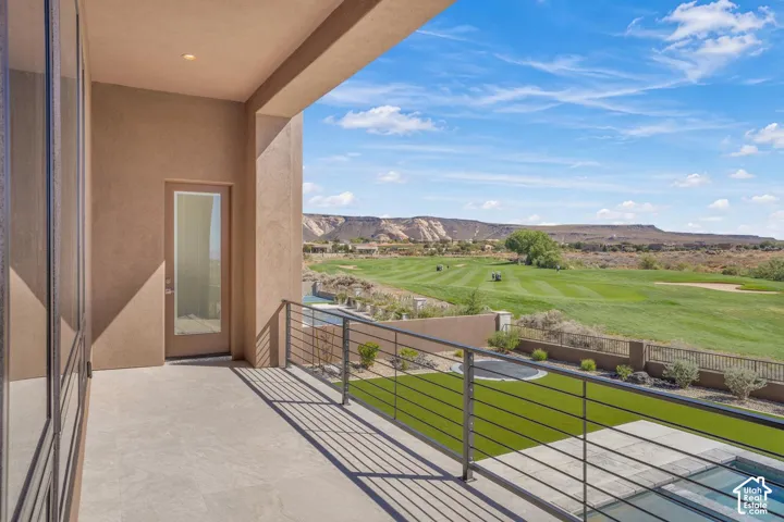 Covered balcony featuring large-format stone-style flooring, a horizontal cable railing system, and direct exterior access