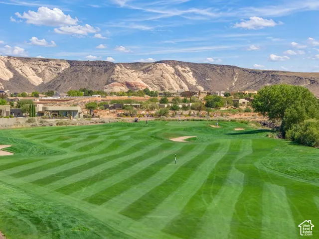 Expansive golf course grounds featuring manicured turf, sand bunkers, and mountain scenery