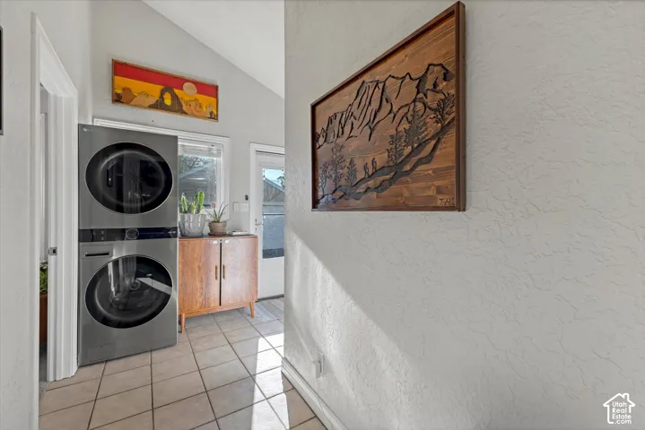 Utility space featuring ceramic tile flooring, vaulted ceiling, and an exterior door
