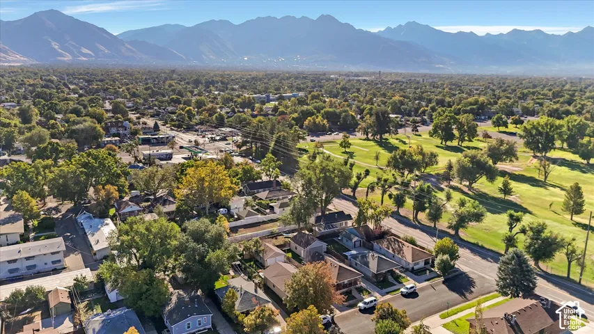 Aerial perspective featuring expansive mountain range backdrop and proximity to mature greenery and local golf course fairways