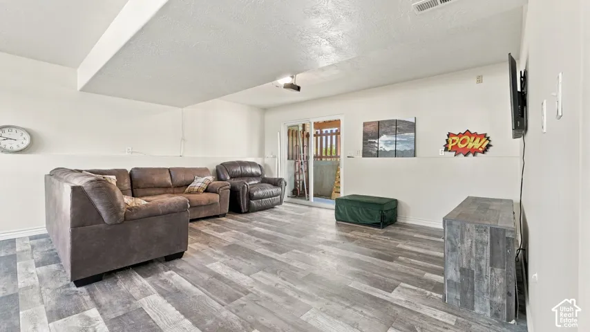 Interior space featuring wood-finish plank flooring, neutral wall tones, and glass sliding doors providing exterior access