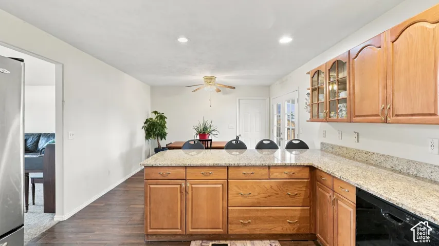 Kitchen featuring wood cabinetry, stone countertops, integrated recessed lighting, wood-finish flooring, and a ceiling fan