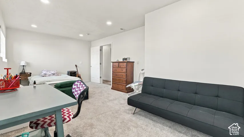 Neutral wall color, wall-to-wall carpeting, recessed ceiling lighting, and a six-panel interior door