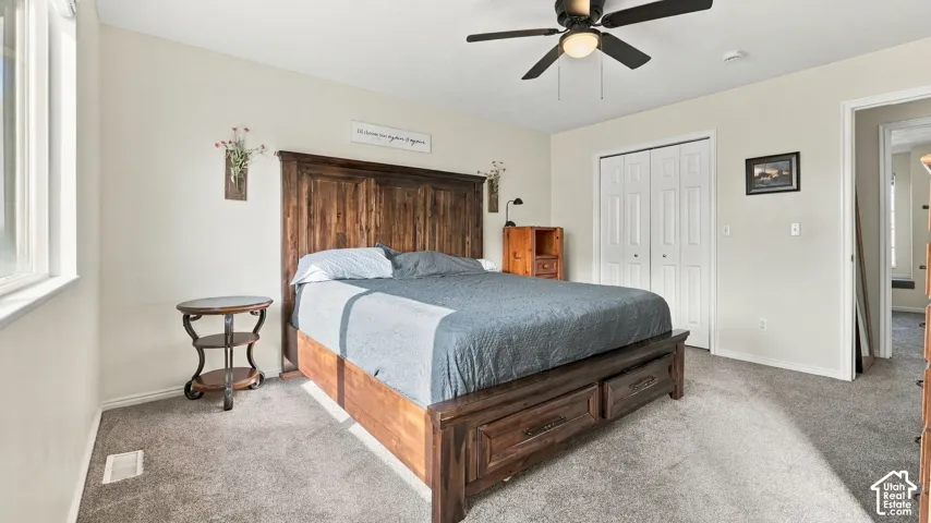 Neutral wall palette, ceiling fan with integrated lighting, and dual-panel closet doors with white trim