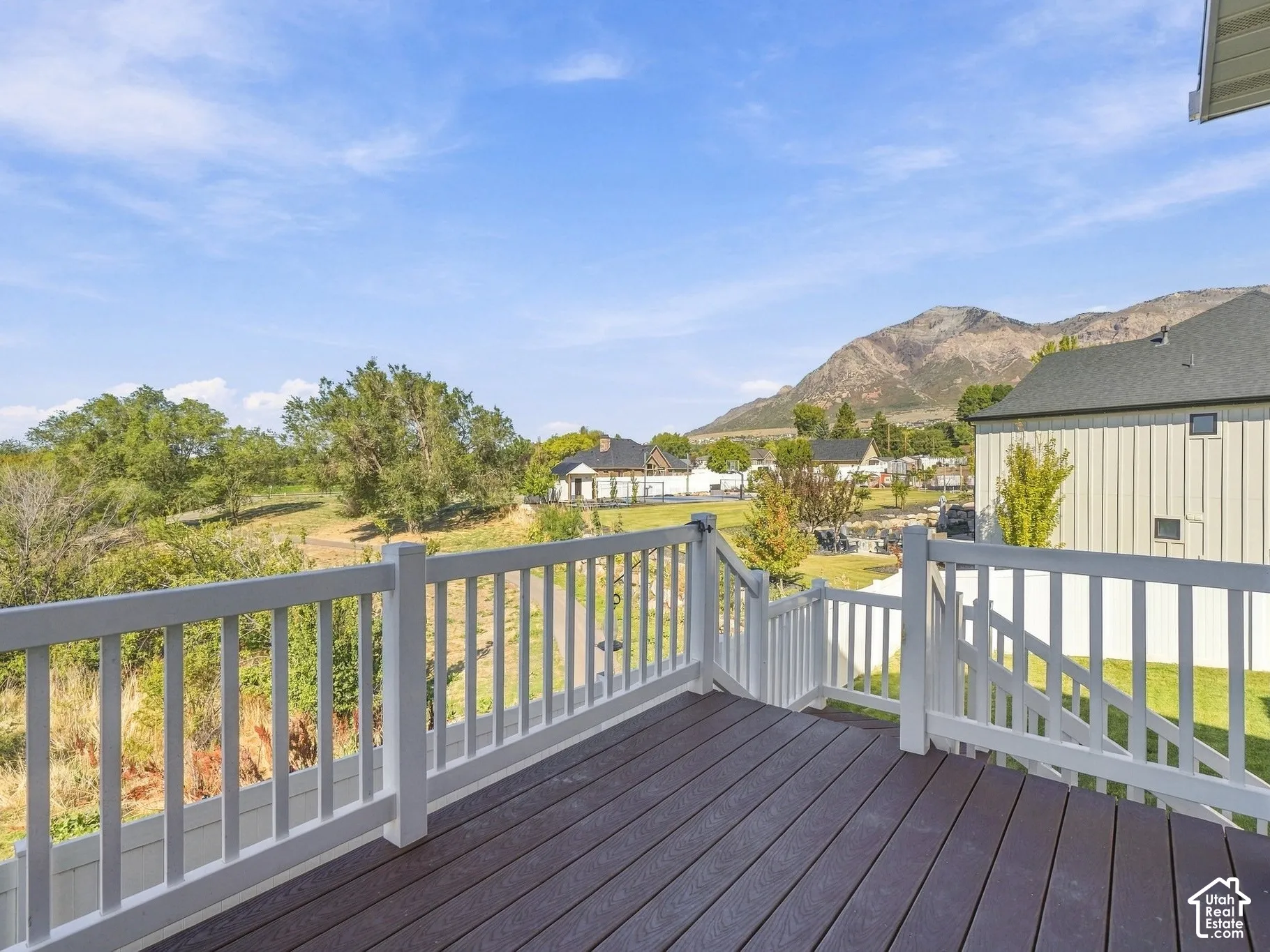 Elevated deck featuring composite decking, white baluster railings, and mountain scenery