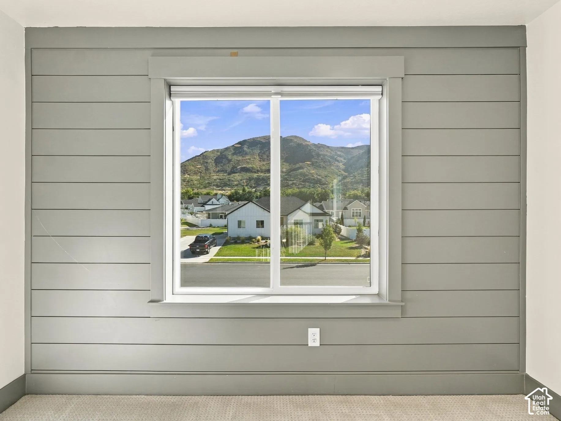 Neutral-toned horizontal shiplap wall detail featuring a center window with a mountain backdrop