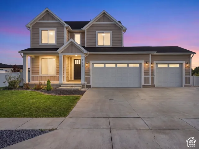 Two-story residence featuring horizontal lap siding, a covered front entry with columns, a three-car garage, and a concrete driveway