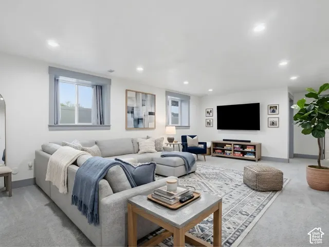 Neutral wall-to-wall carpeting, recessed ceiling lighting, and double-pane windows with gray trim