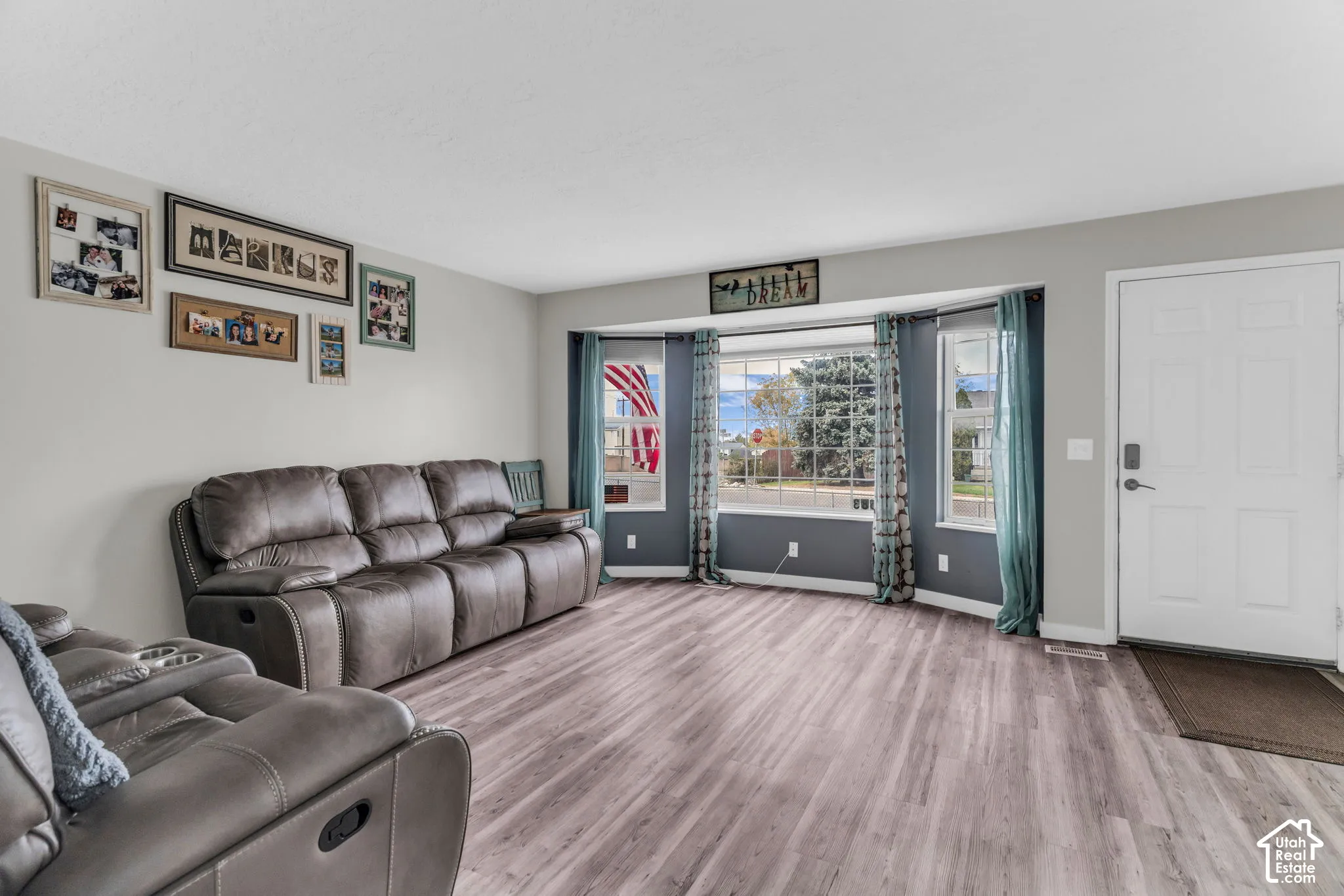 Living space featuring wood-finish flooring, a multi-pane bay window, and a paneled exterior door