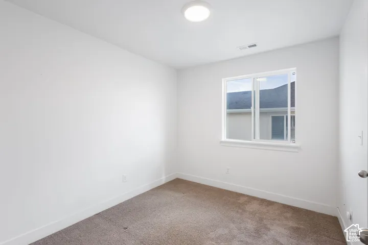 Bright, light-filled bedroom featuring neutral wall finishes, recessed ceiling lighting, and a large double-hung window with white trim framing mountain scenery