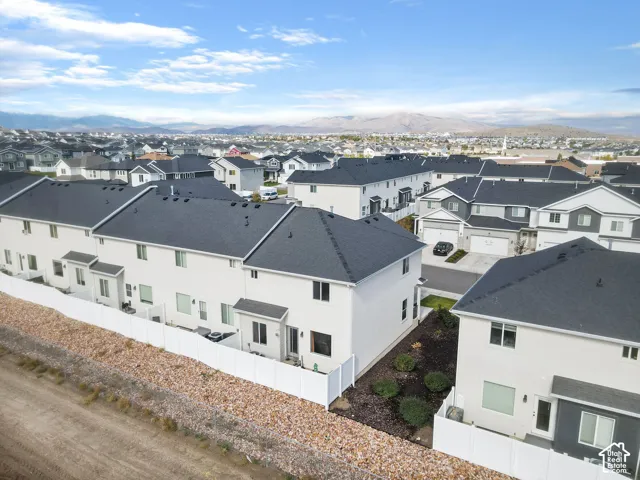 Modern residential community featuring contemporary white exterior finishes, dark asphalt roofing, and multi-unit architecture with clean geometric lines