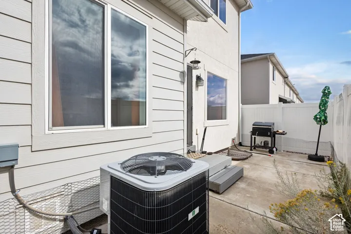 Exterior space featuring horizontal siding, dual-pane windows, a concrete patio, and a perimeter vinyl fence