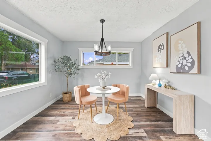 Neutral interior with wood-finish flooring, crisp window casings, and a multi-light chandelier