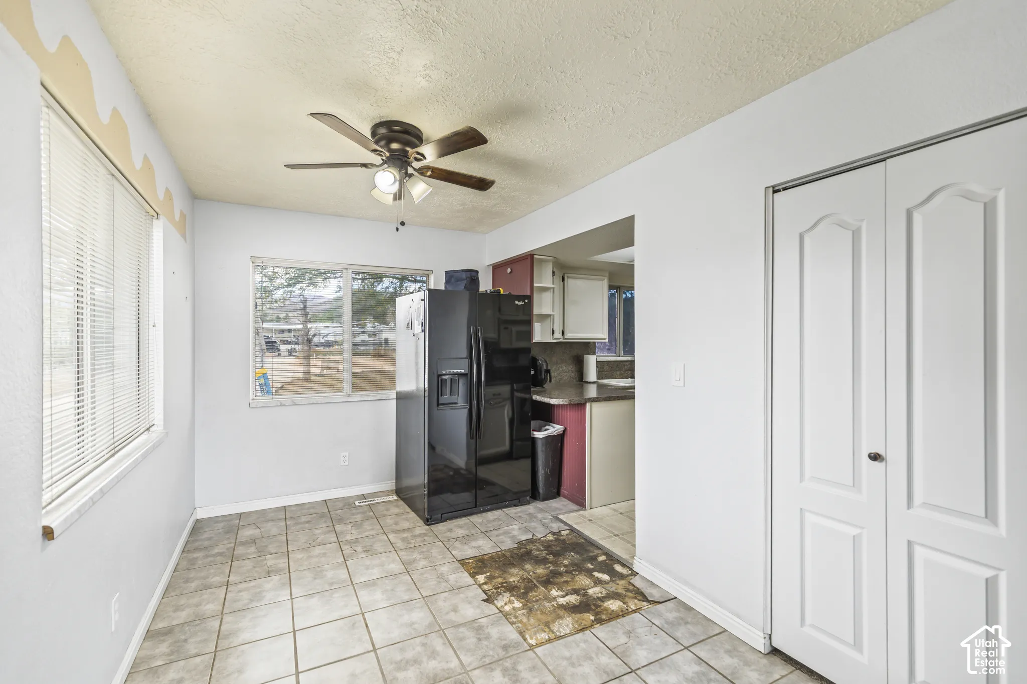 Room featuring ceramic tile flooring, a ceiling fan with integrated lighting, dual-pane windows, and white bifold closet doors