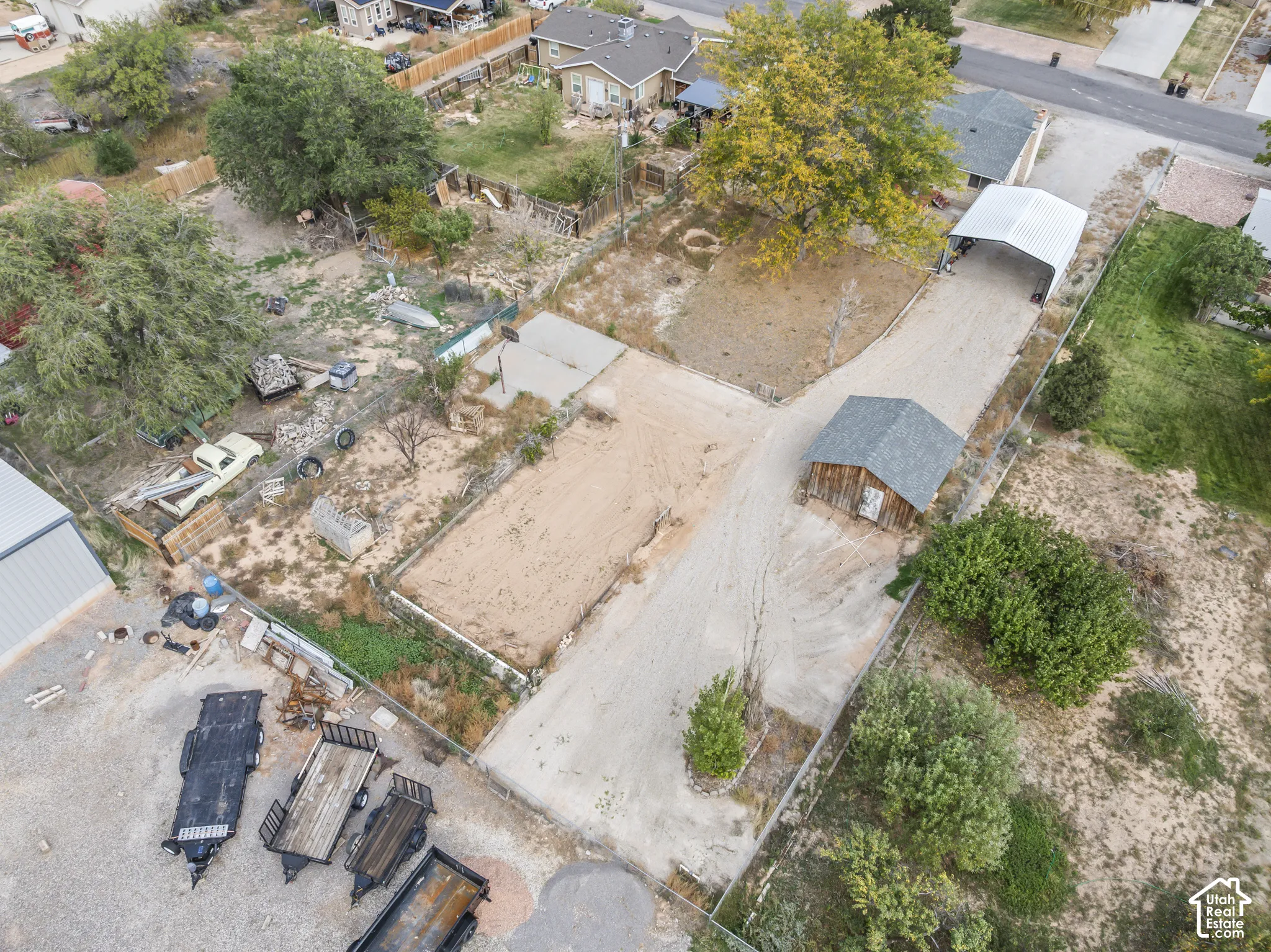 Expansive lot featuring a detached shed, graveled driveway, and metal carport structure