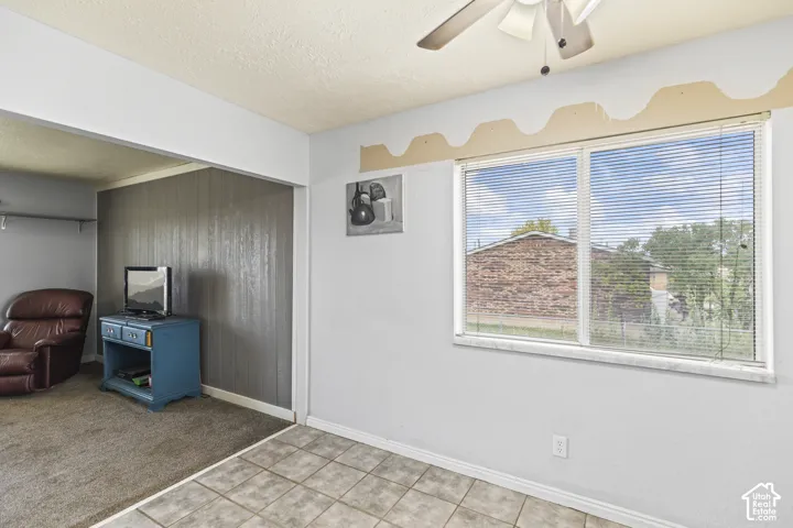 Interior space featuring ceramic tile flooring, horizontal window blinds, and a ceiling fan