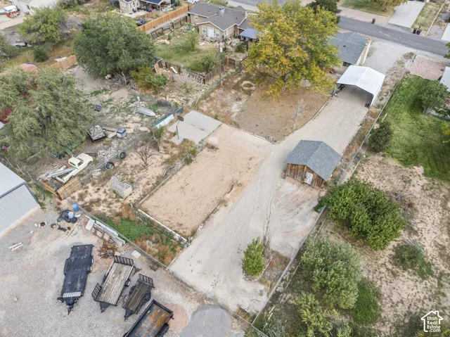 Expansive lot featuring a detached shed, graveled driveway, and metal carport structure