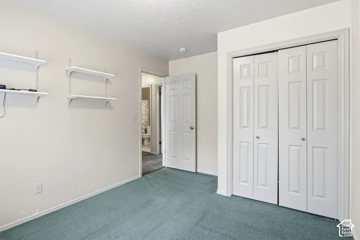 Room featuring wall-mounted shelving, six-panel interior door, and bi-fold closet doors
