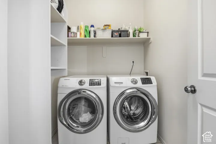 Laundry area featuring built-in vertical shelving, a horizontal overhead storage shelf, and a six-panel interior door