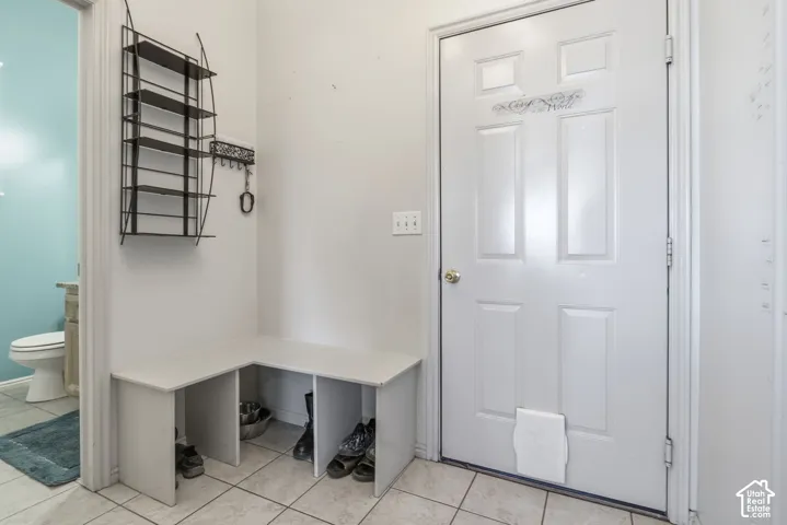 Entryway featuring ceramic tile flooring, a built-in corner storage bench, and an exterior door with a pet door insert