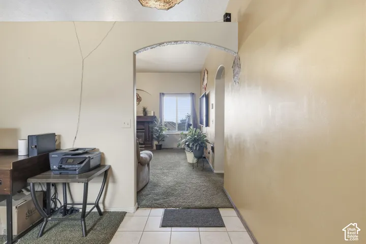 Ceramic tile flooring, textured wall finishes, and architectural arched doorways