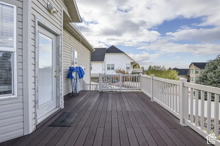 Elevated deck featuring horizontal composite decking, light-colored vertical picket railing, and a gated entrance