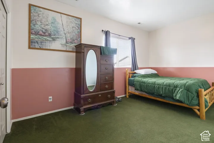 Interior room featuring two-tone wall paint, carpeting, and a single window with horizontal blinds