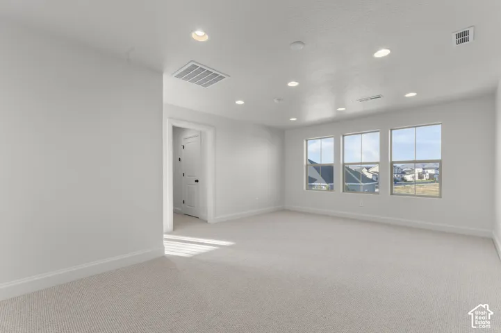 Neutral wall color, wall-to-wall carpeting, recessed ceiling lighting, and multi-pane windows