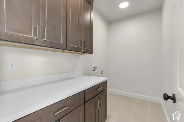 Built-in cabinetry with dark wood-finish, stone-surfaced countertop, integrated recessed lighting, and tile flooring