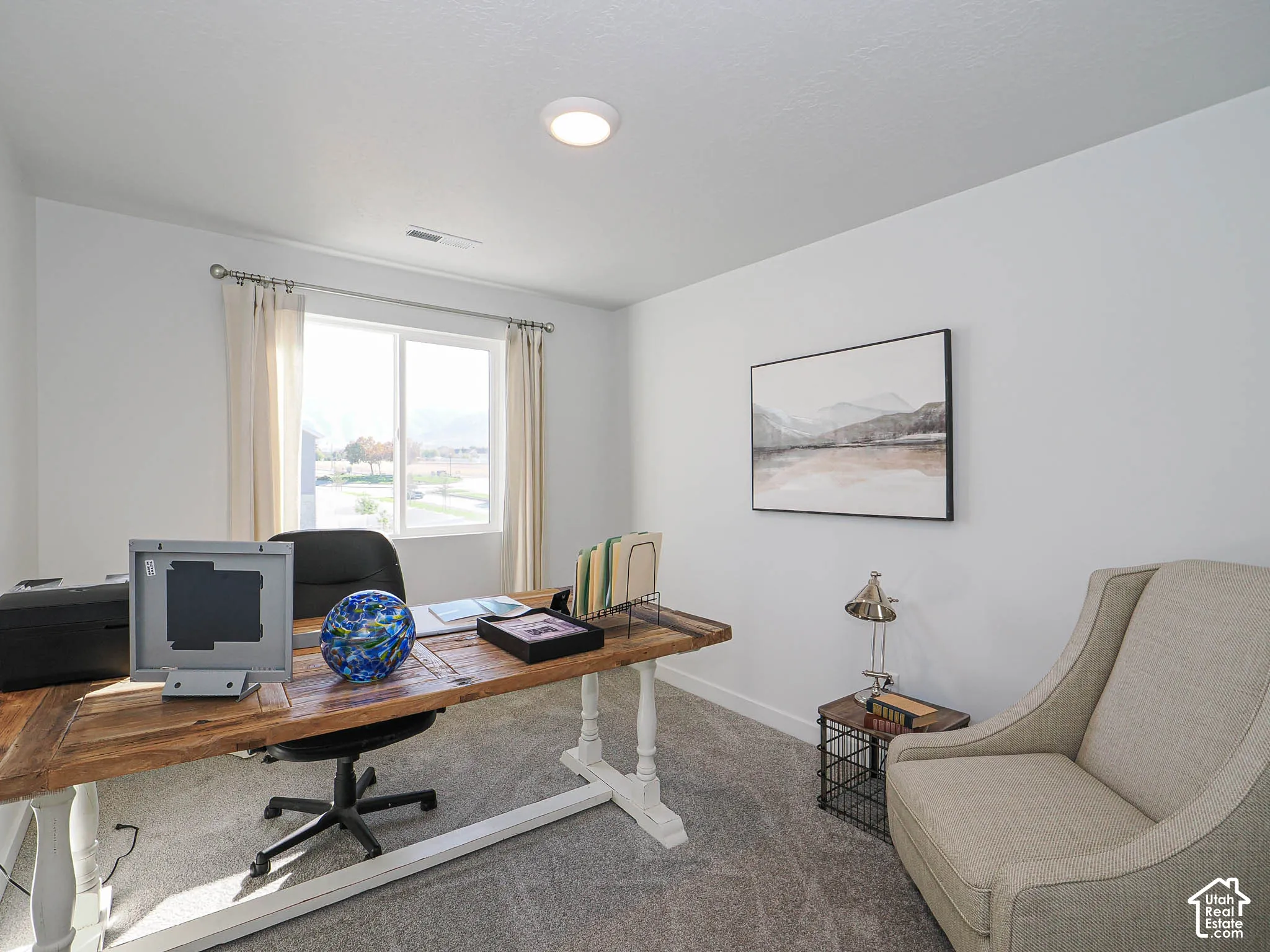 Neutral-toned wall-to-wall carpeting, crisp white walls, and a large slider window allowing abundant natural light