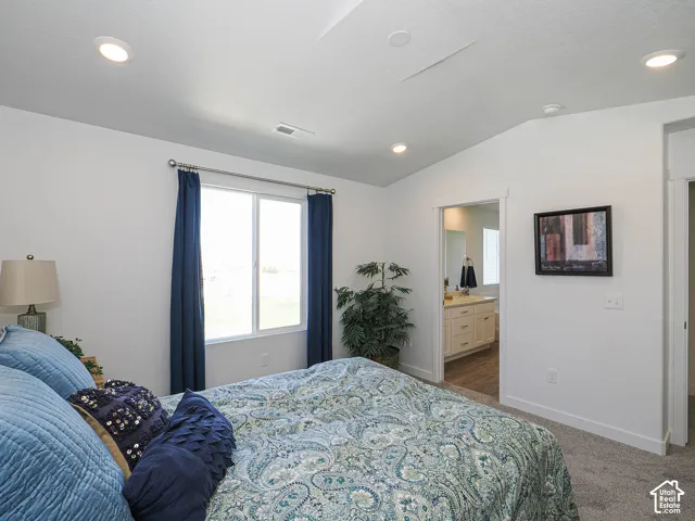 Neutral-toned wall-to-wall carpeting, recessed ceiling lighting, and large sliding window with white trim