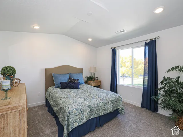 Vaulted ceilings, recessed lighting, and wall-to-wall carpeting featuring a large window with horizontal slider operation