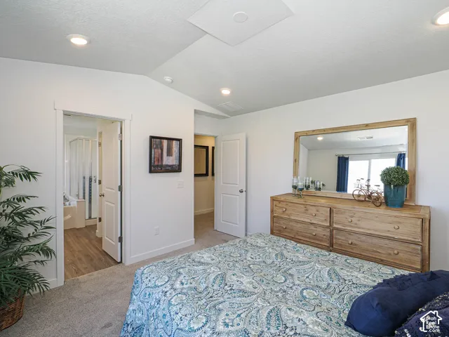 Vaulted ceilings, recessed lighting, and wall-to-wall carpeting featuring two interior doorways with paneled doors