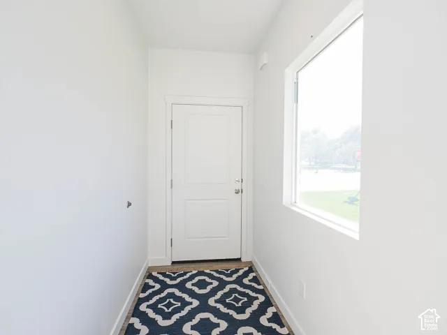 Entryway featuring a white paneled door, wood-finish flooring, and a large window