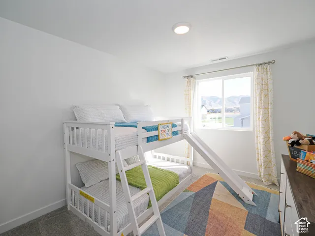 Neutral wall color, carpeted flooring, flush-mount ceiling light, and window with exterior mountain scenery