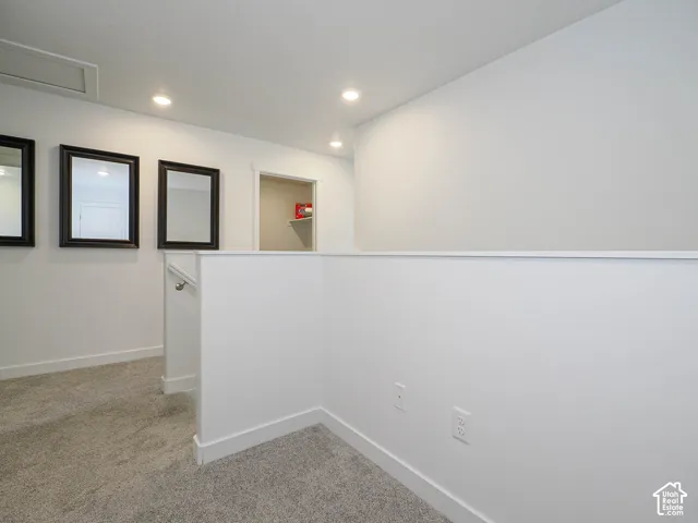 Neutral wall palette with recessed lighting and carpeted flooring