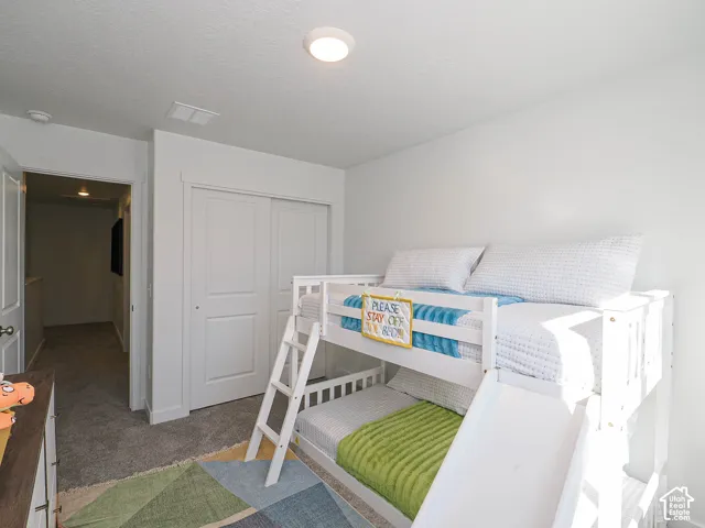 Neutral wall tones, carpeted flooring, and double-panel closet doors with cased molding