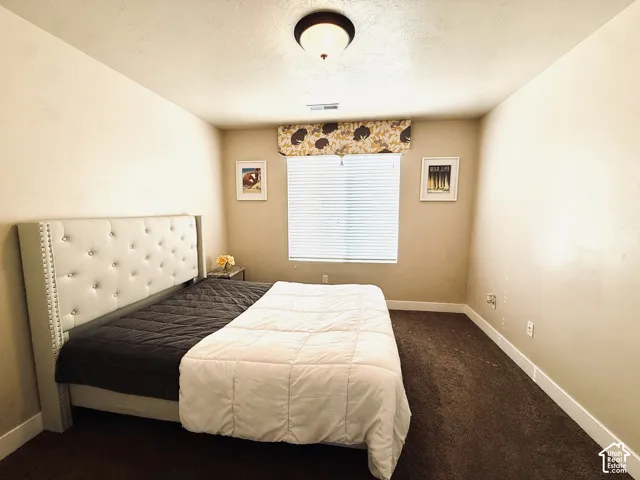 Perfect 2nd bedroom featrures fresh neutral paint, plush carpeting, single-pane window with fabric valance, horizontal blinds, and a central ceiling-mounted light fixture