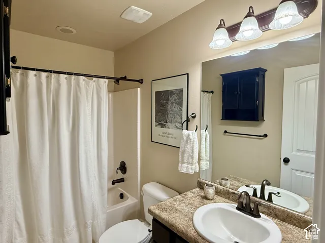 2nd Bathroom features a vanity with a granite countertop, undermount sink, oil-rubbed bronze faucet, built-in wall cabinetry, and a full-width mirror with a three-light fixture