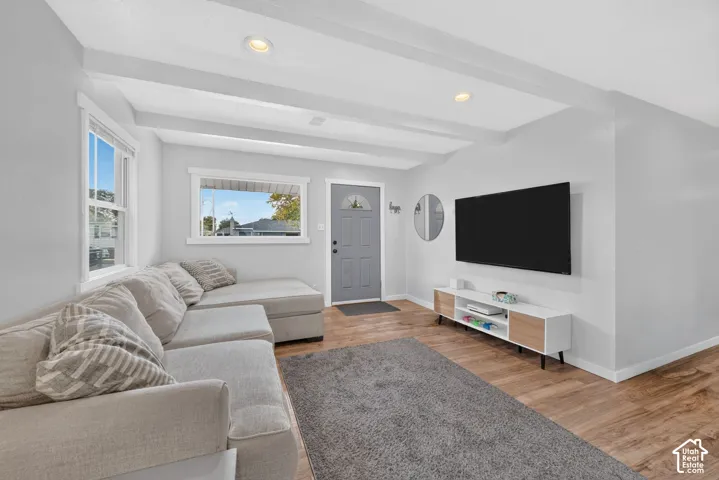 Another view of the living room, looking toward the front door. Windows on two walls bring in light.