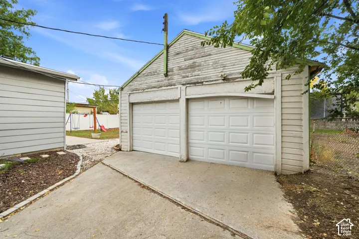 The detached two-car garage has two doors onto a concrete drive. A path leads from here to the backyard.