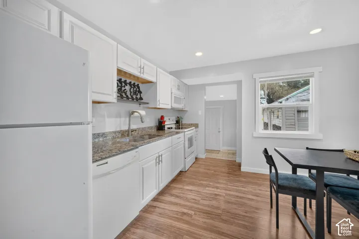 Another view of the kitchen, looking toward the back of the house. A doorway leads to the tiled back entry, and the dining table sits right alongside.