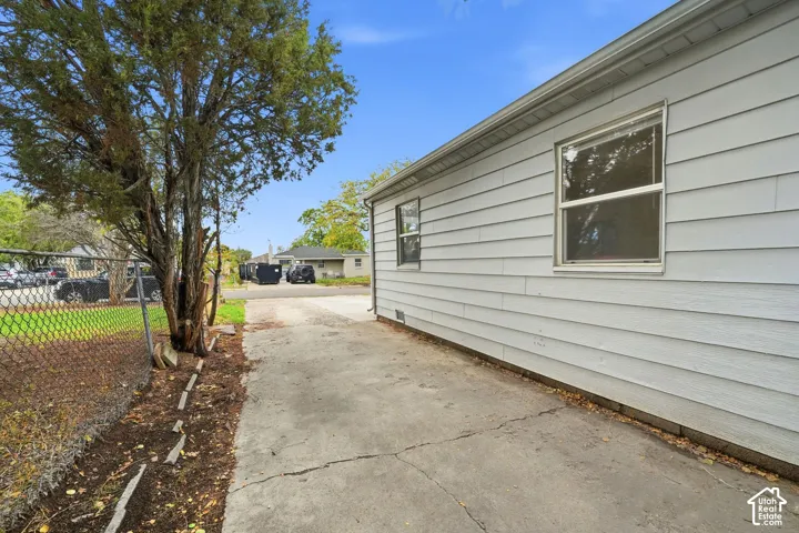 A concrete drive runs along the side of the house toward the backyard and garage.