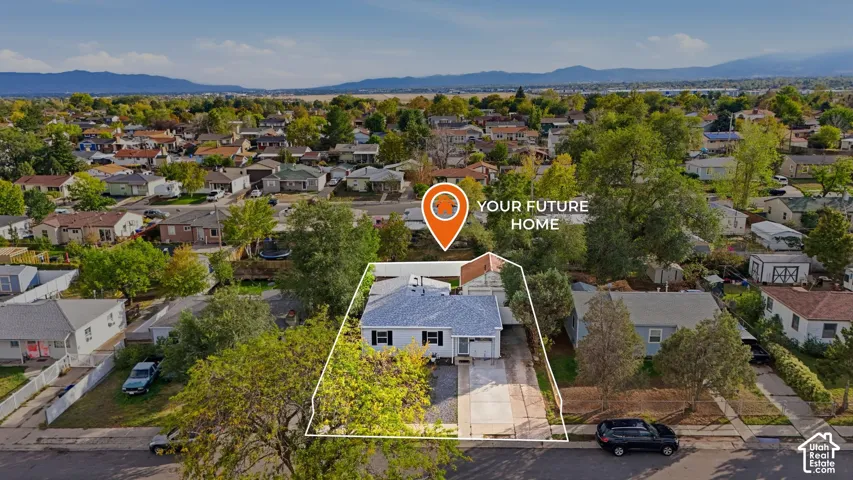 From the front, the outline shows the house, driveway and garage, with the fenced yard behind. Mountains line the skyline.