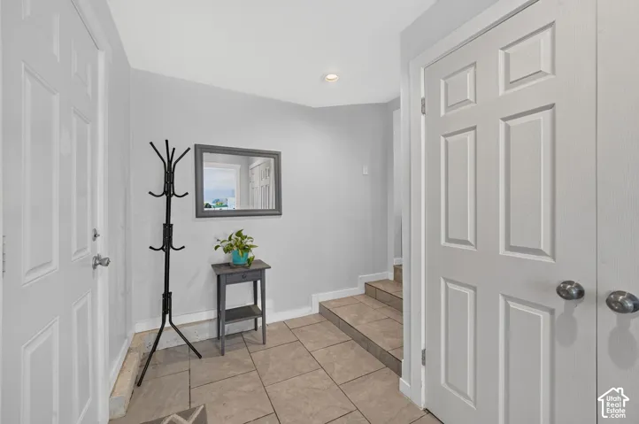 Another view of the back entry, with a coat rack and a console table. The laundry is behind the double doors on the right, and the kitchen is up the steps.