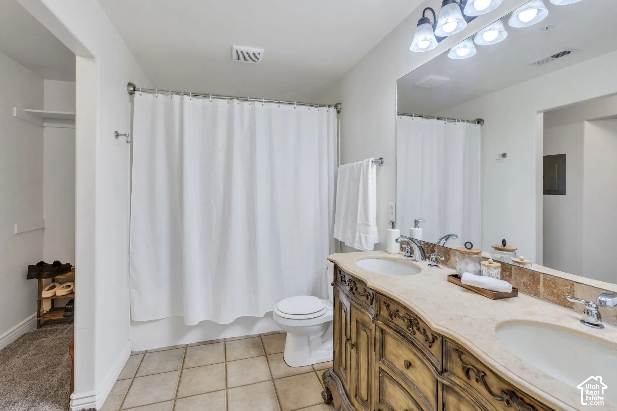 Ensuite bathroom featuring double sinks and a walk-in closet