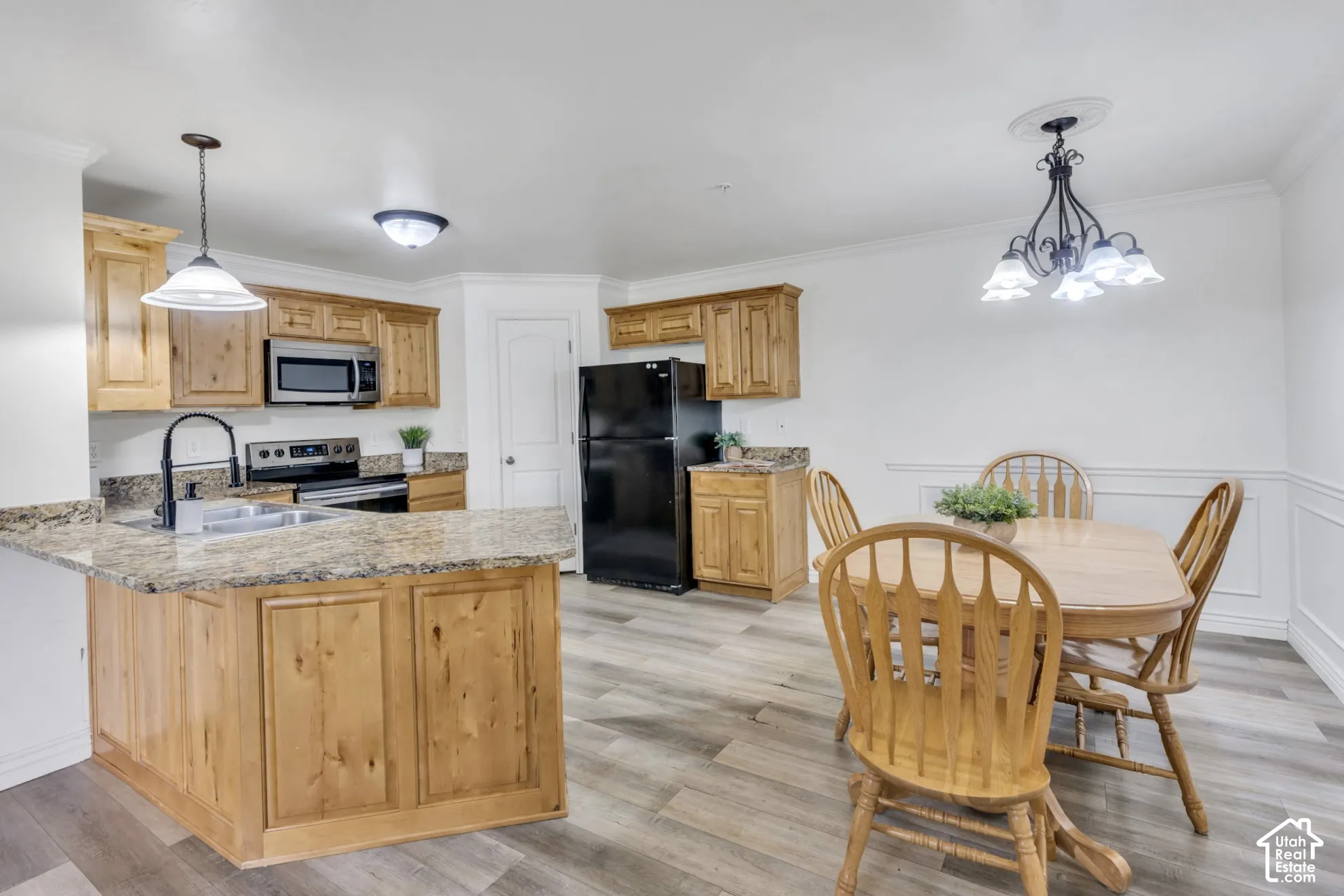 Kitchen featuring wood-finish cabinetry, granite countertops, LVP flooring, plenty of dining space