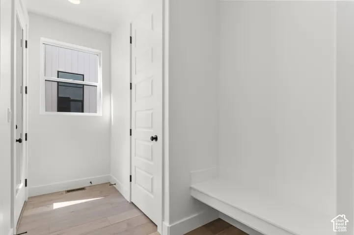 Built-in bench seating, wood-finish flooring, five-panel interior door, and single-hung window featuring matte black hardware